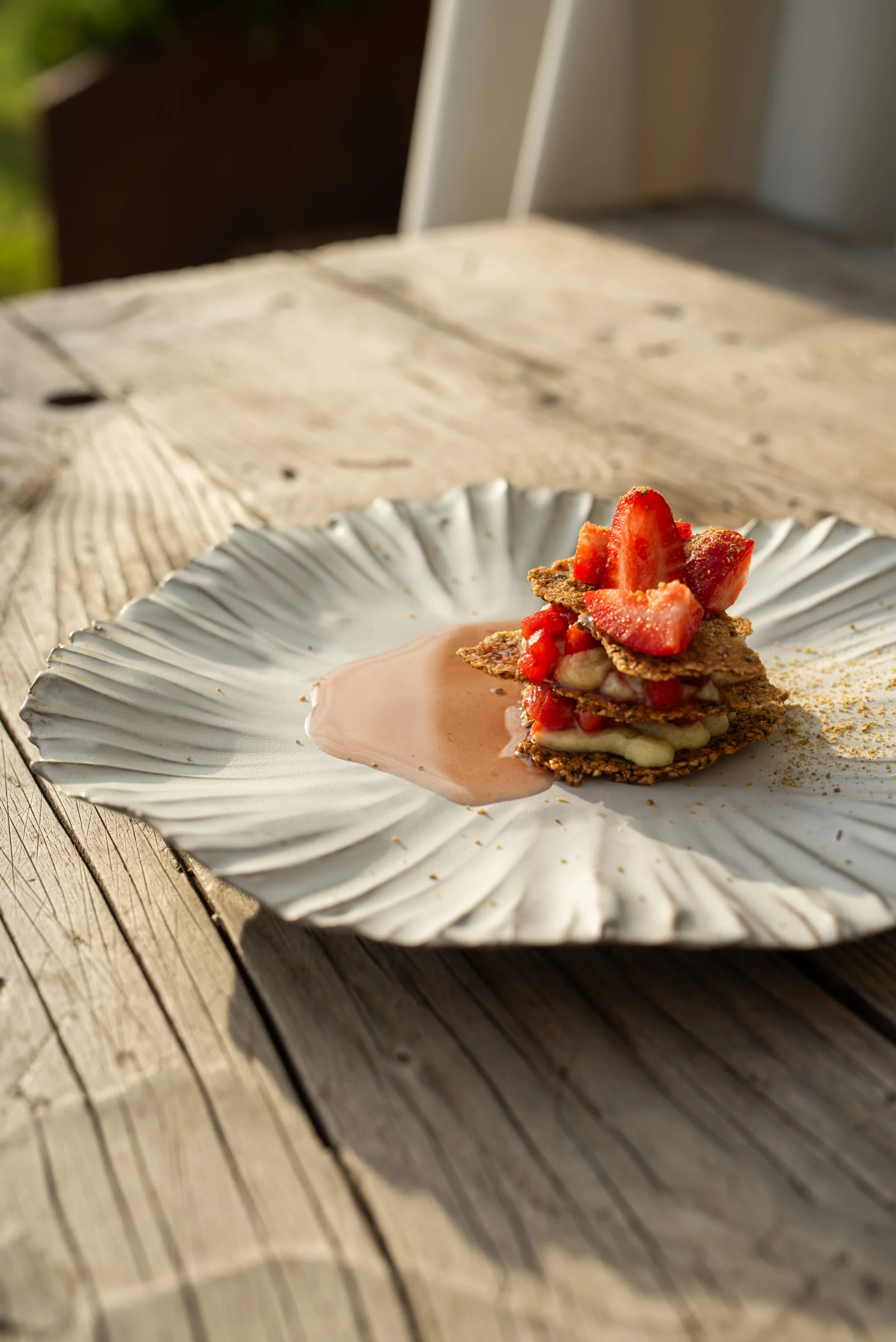 A plated strawberry dessert on a ceramic plate on a wooden table